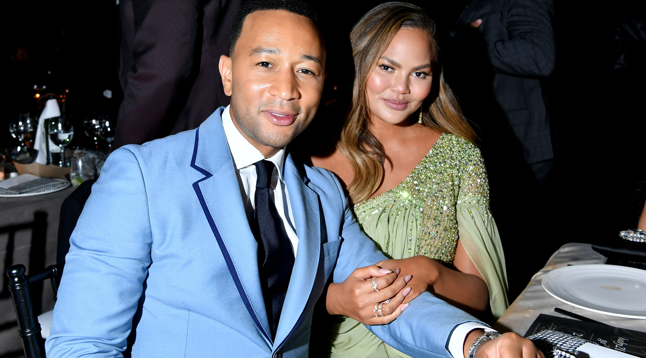 chrissy teigen and john legend sitting together at en event