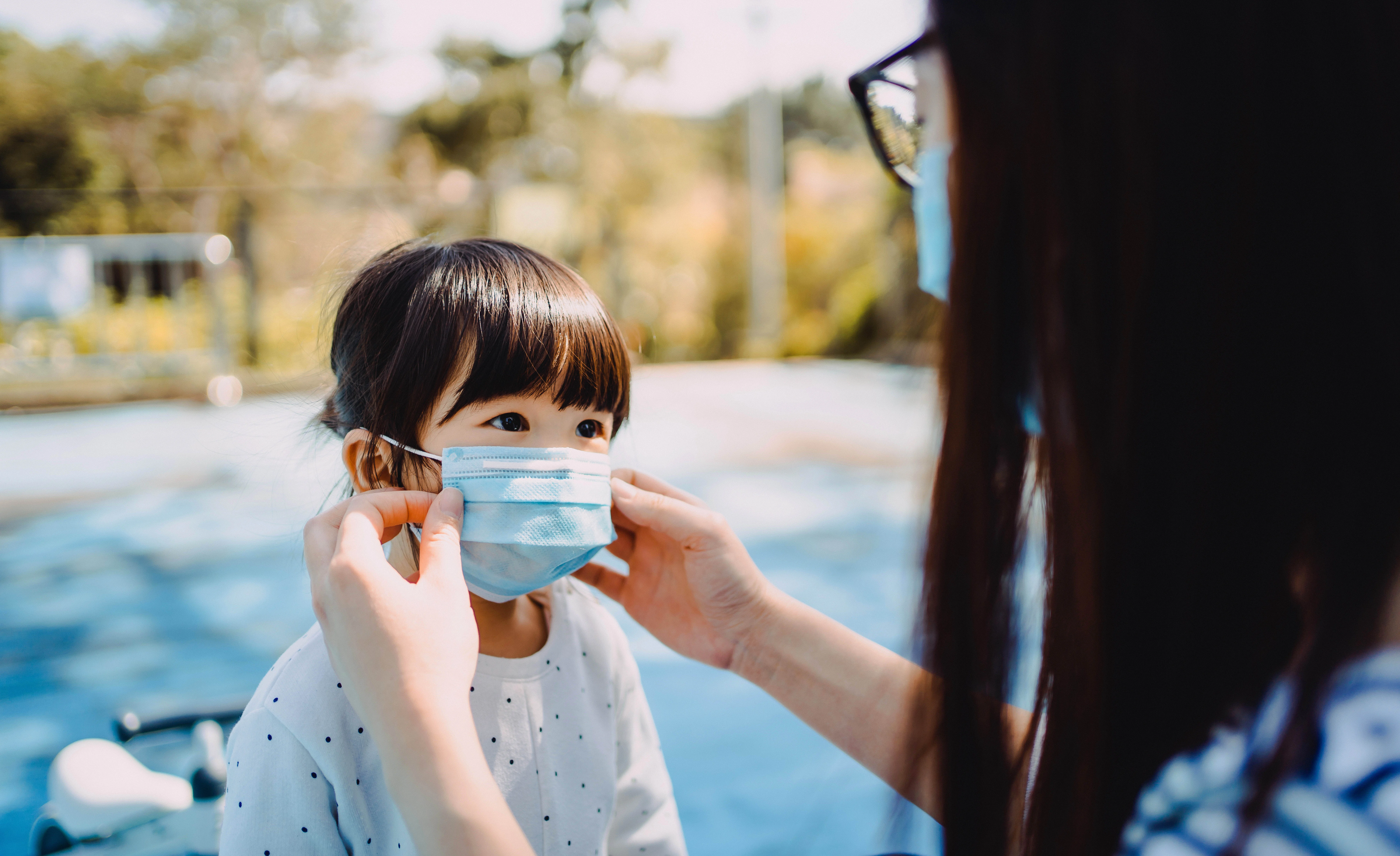 child wears mask before attending summer camp