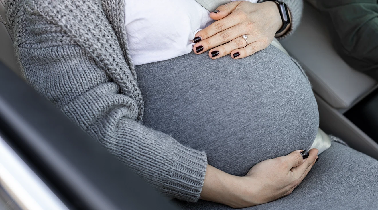 close up of pregnant woman sitting in passenger seat of car