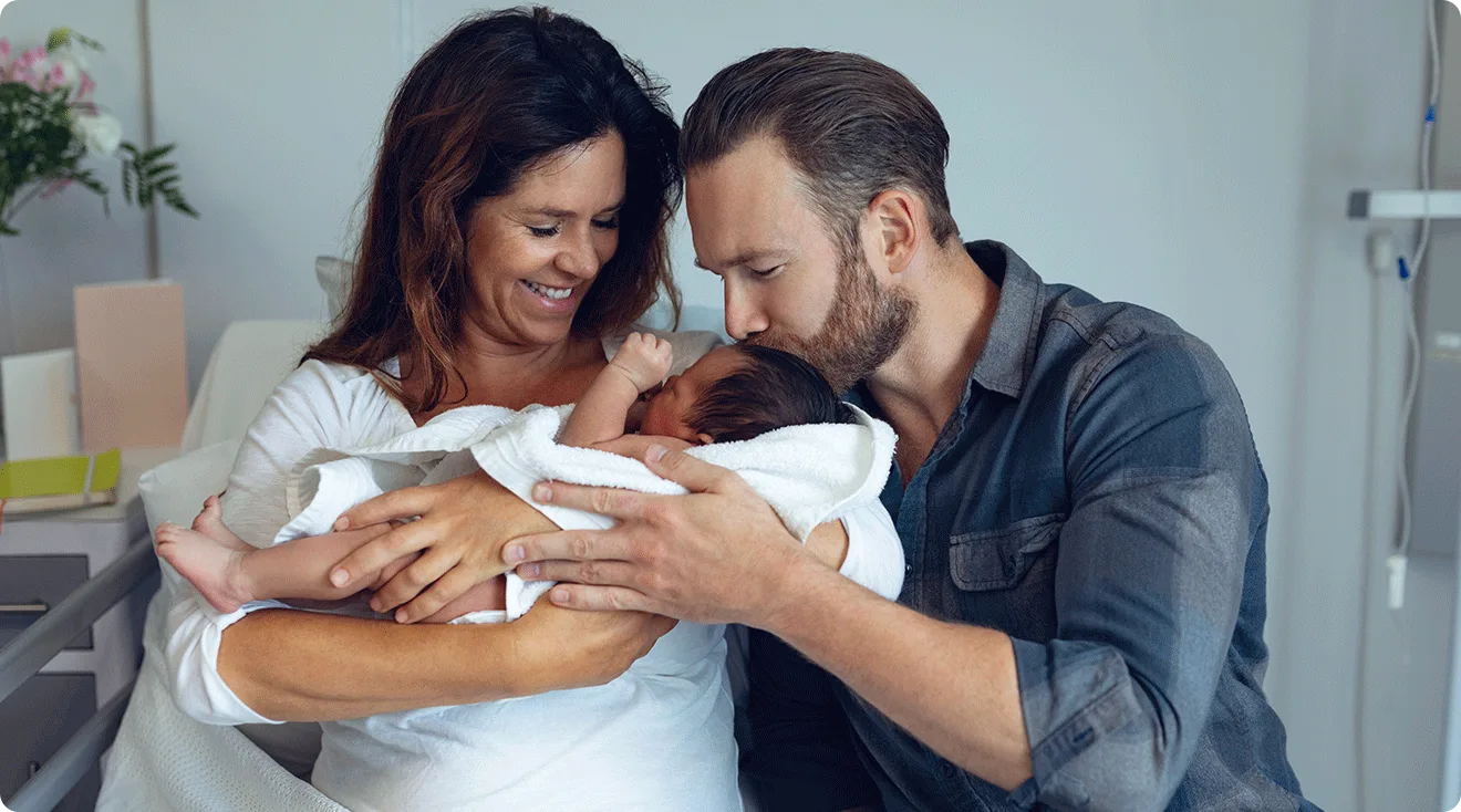 parents holding newborn baby in hospital