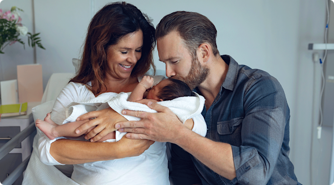 parents holding newborn baby in hospital