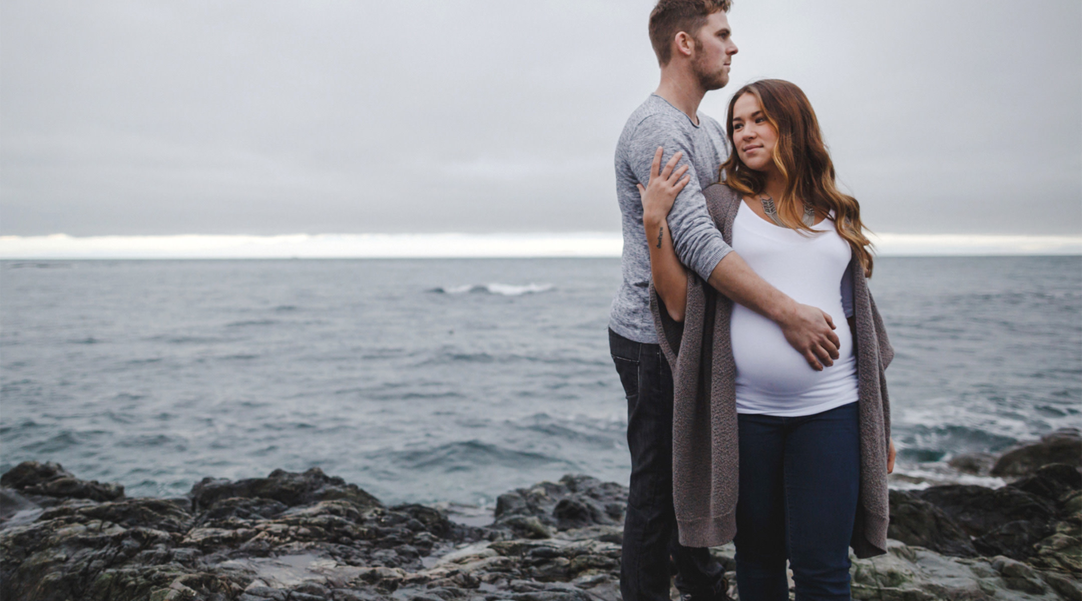 pregnant couples looking into distant unhappy