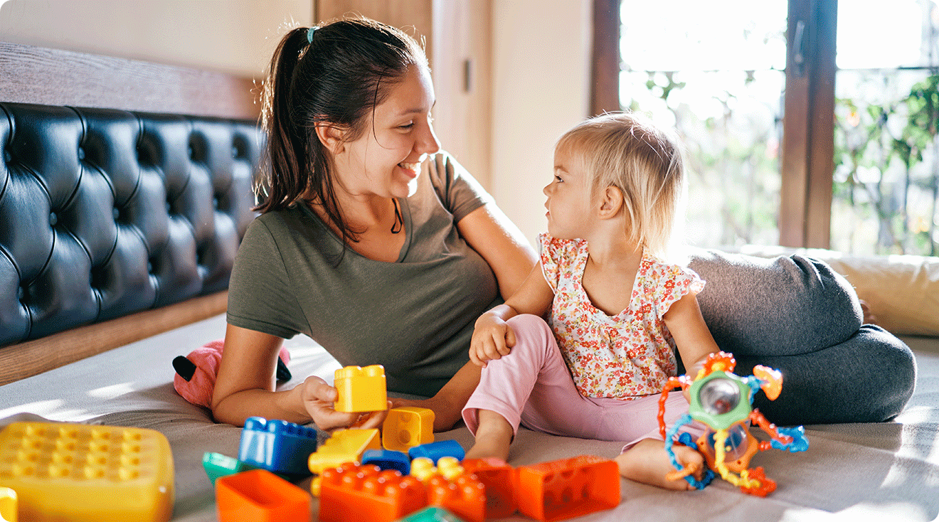mom talking to toddler while playing with toys at home