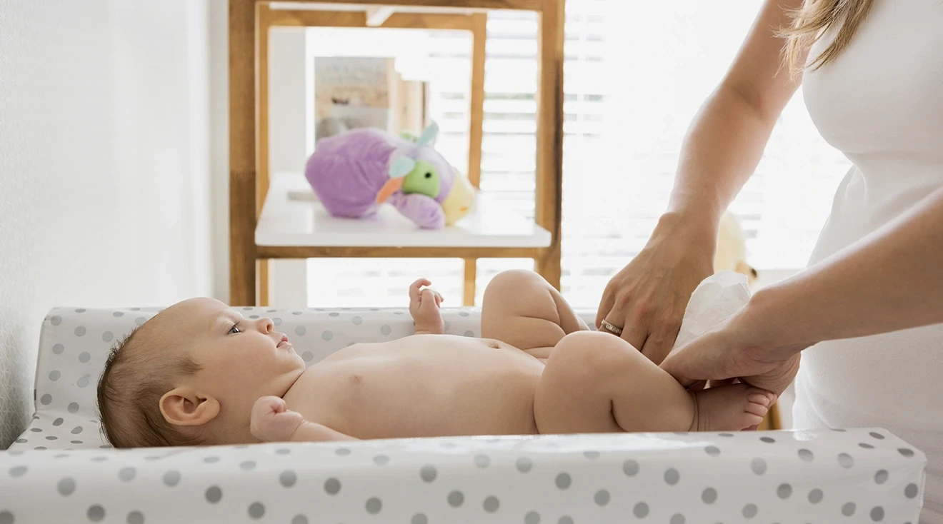 mother changing baby's diaper