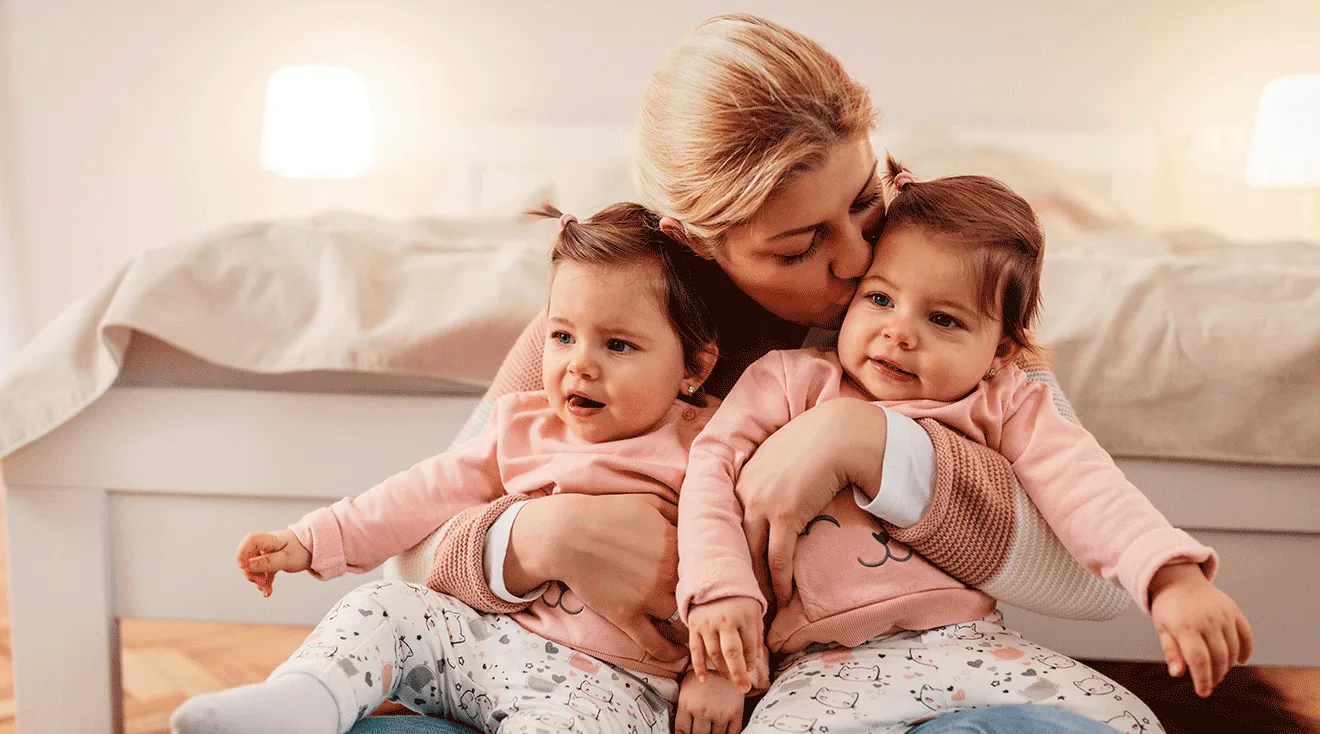 mom hugging twin toddler girls