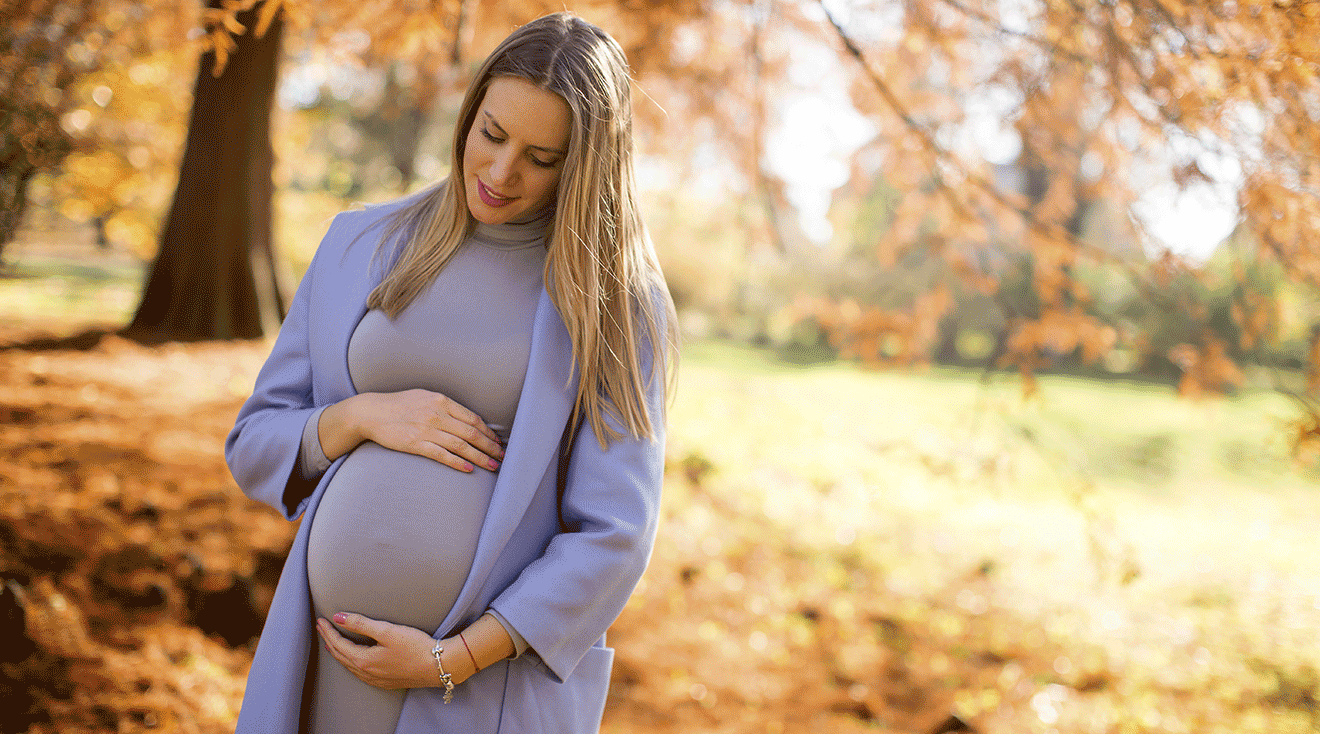 pregnant woman outside during autumn