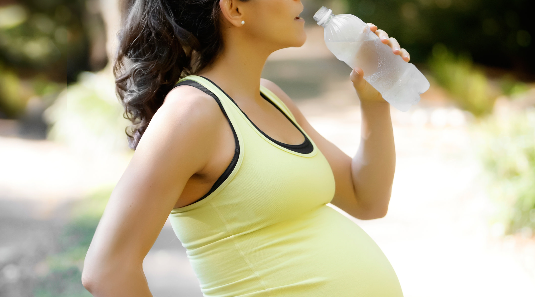 pregnant woman doing fitness and drinking water