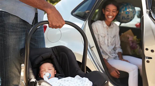 mom and dad bringing newborn baby home