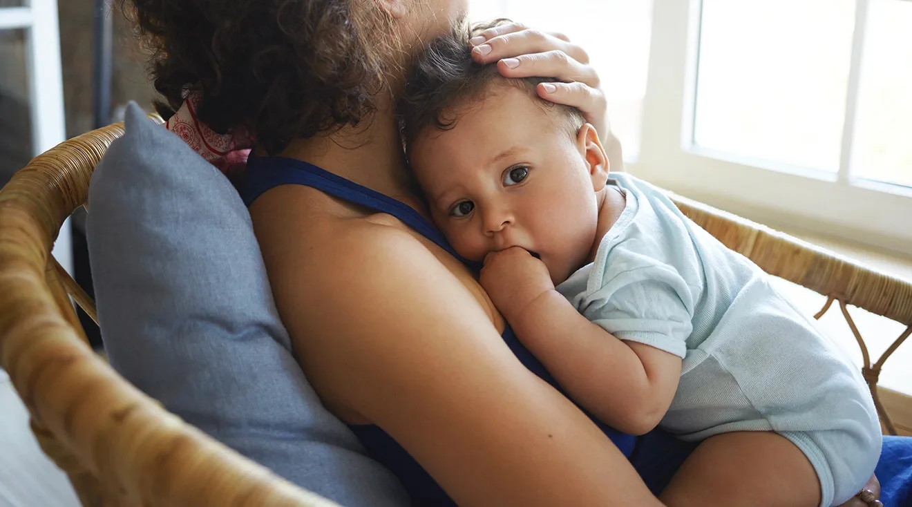 mother holding baby at home