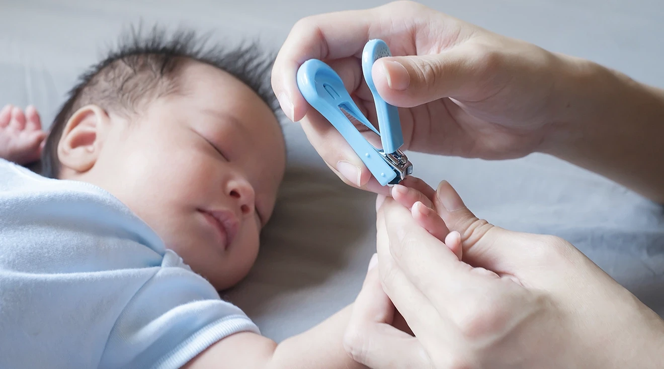 mother clipping baby's nails with baby nail clipper