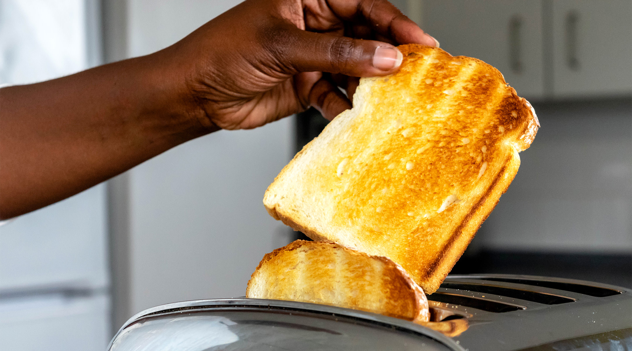 someone taking toast out of toaster