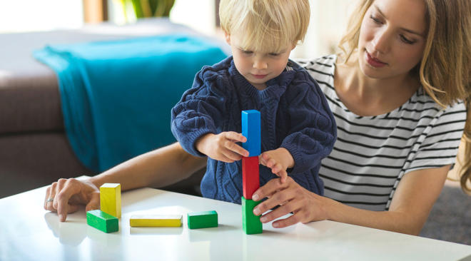 Mom playing blocks with her son. 