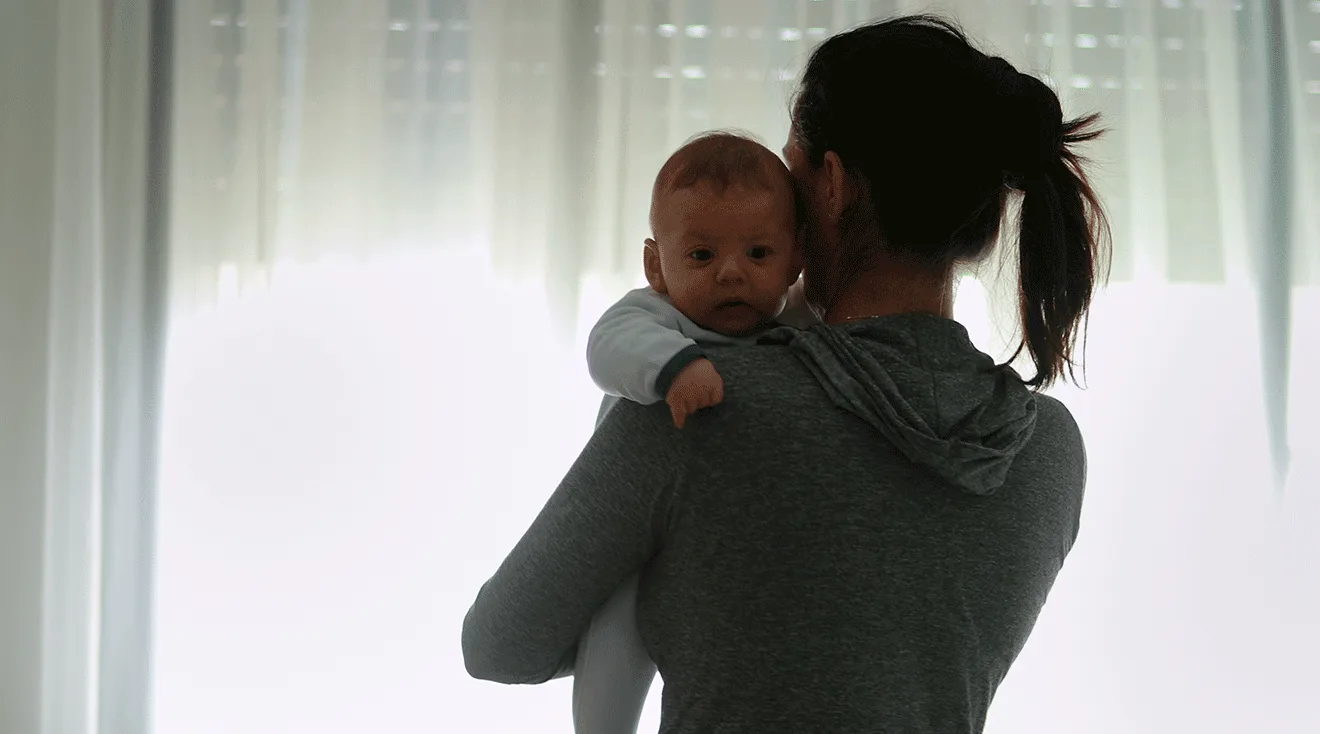 mom holding newborn baby at home