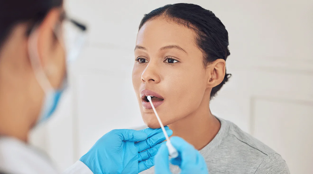 doctor taking mouth swab from female patient