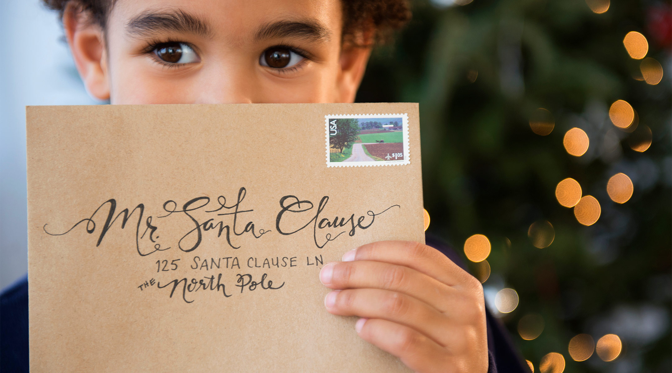 toddler holds envelope addressed to santa