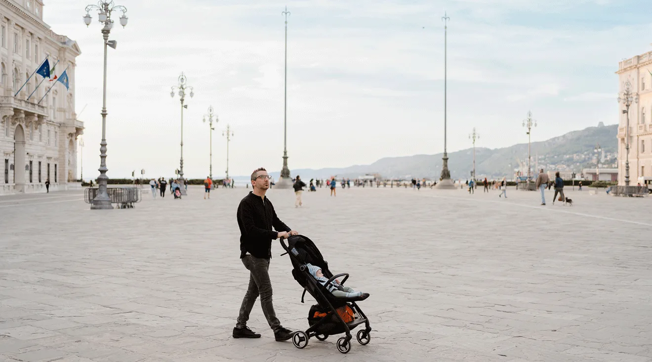 dad pushing stroller while traveling in the city