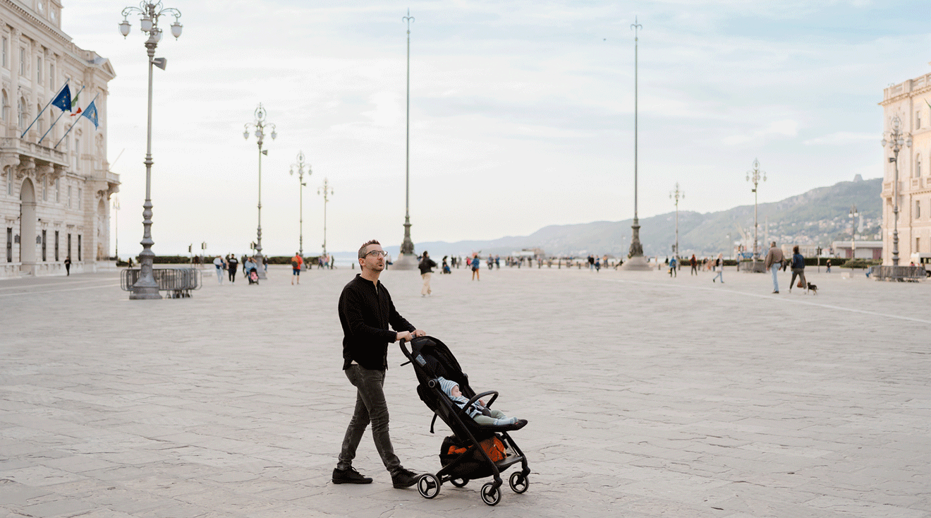 dad pushing stroller while traveling in the city