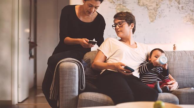 Couple home looking phones baby formula bottle