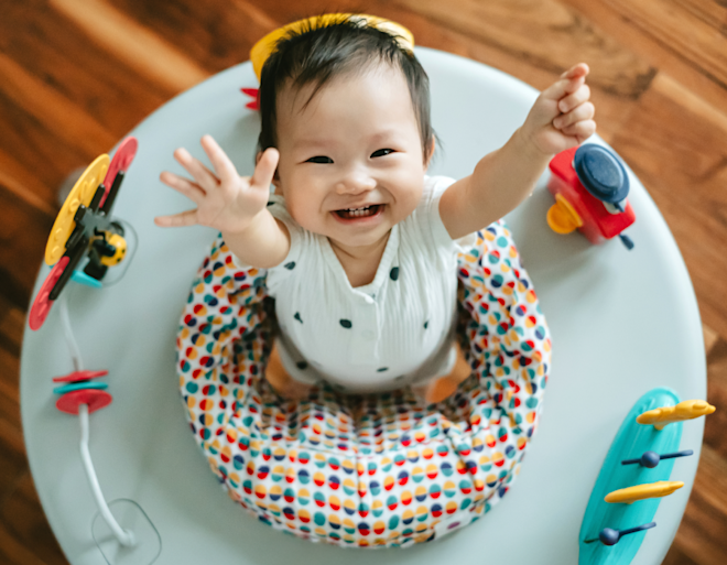 baby in exersaucer reaching for the sky