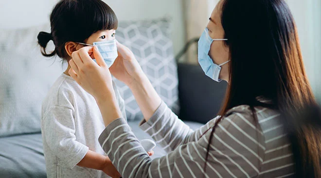mom putting mask on her young child