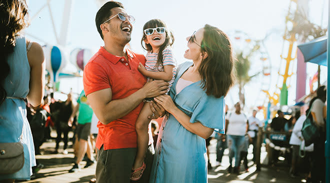 mom, dad and daughter enjoy day at the theme park