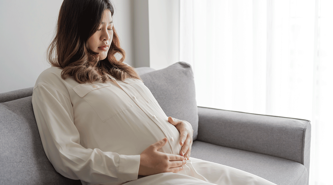 pregnant woman sitting on couch at home