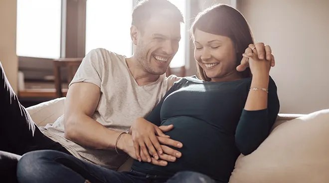husband and wife feeling baby kick inside mother's belly