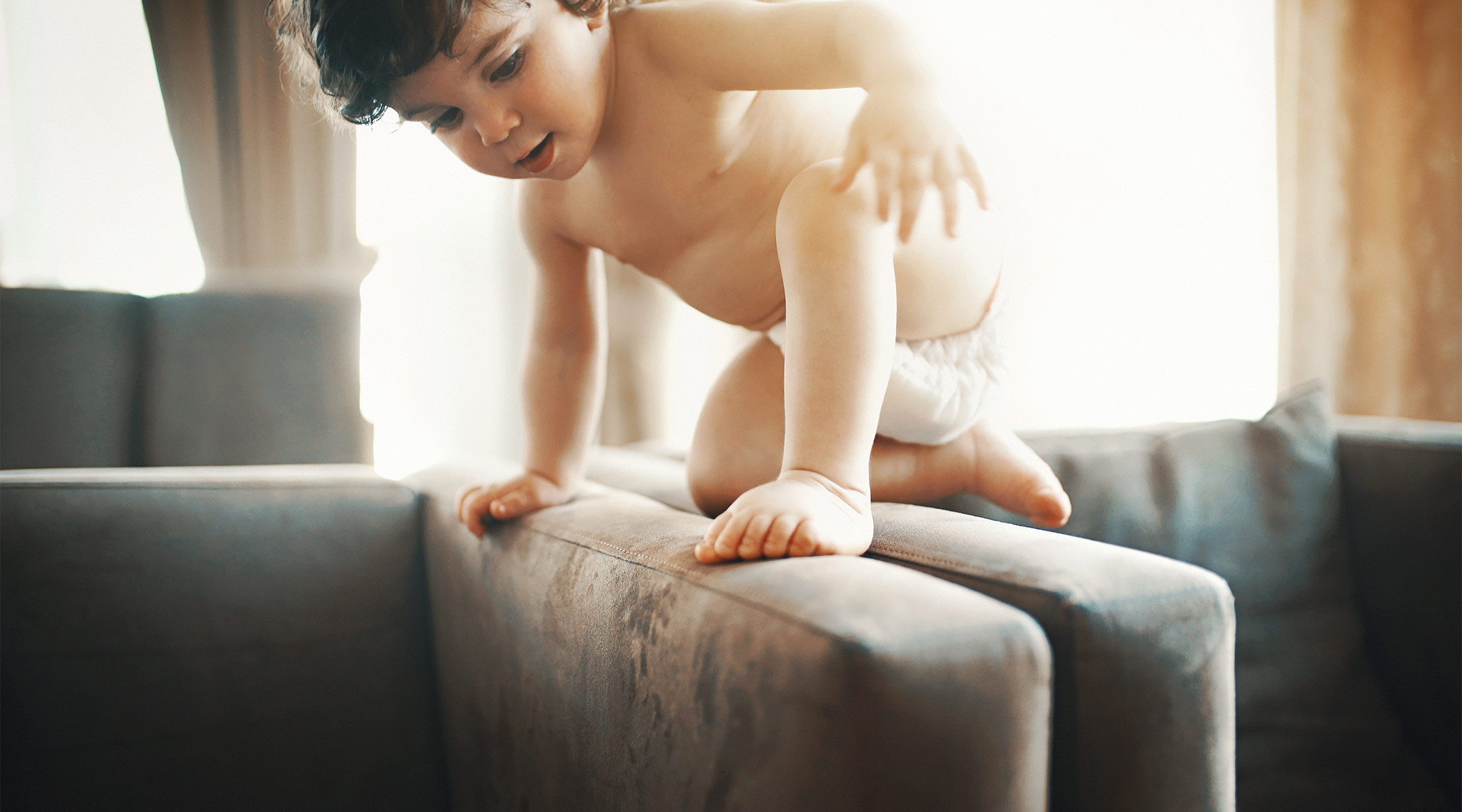 toddler wearing diaper and playing on the couch