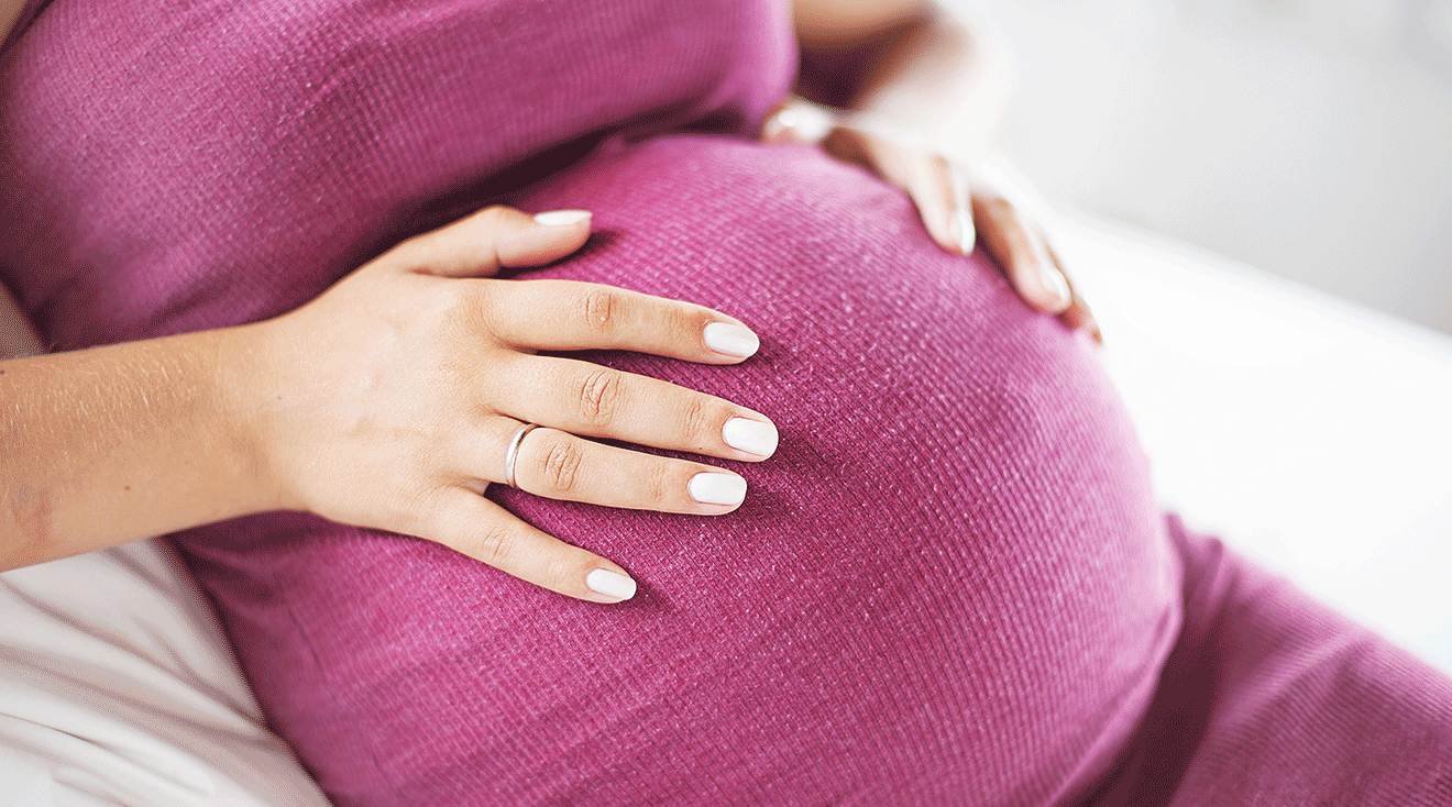 closeup of hands on pregnant belly