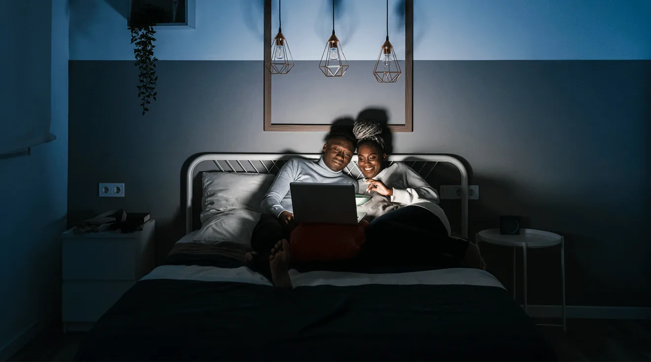couple watching movie in bed late at night