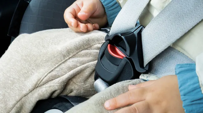 close up of baby buckled in car seat