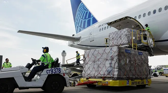 Cargo carrying pallets of baby formula are removed from a United Airlines passenger plane arriving from London Heathrow Airport at the Dulles International Airport June 17, 2022