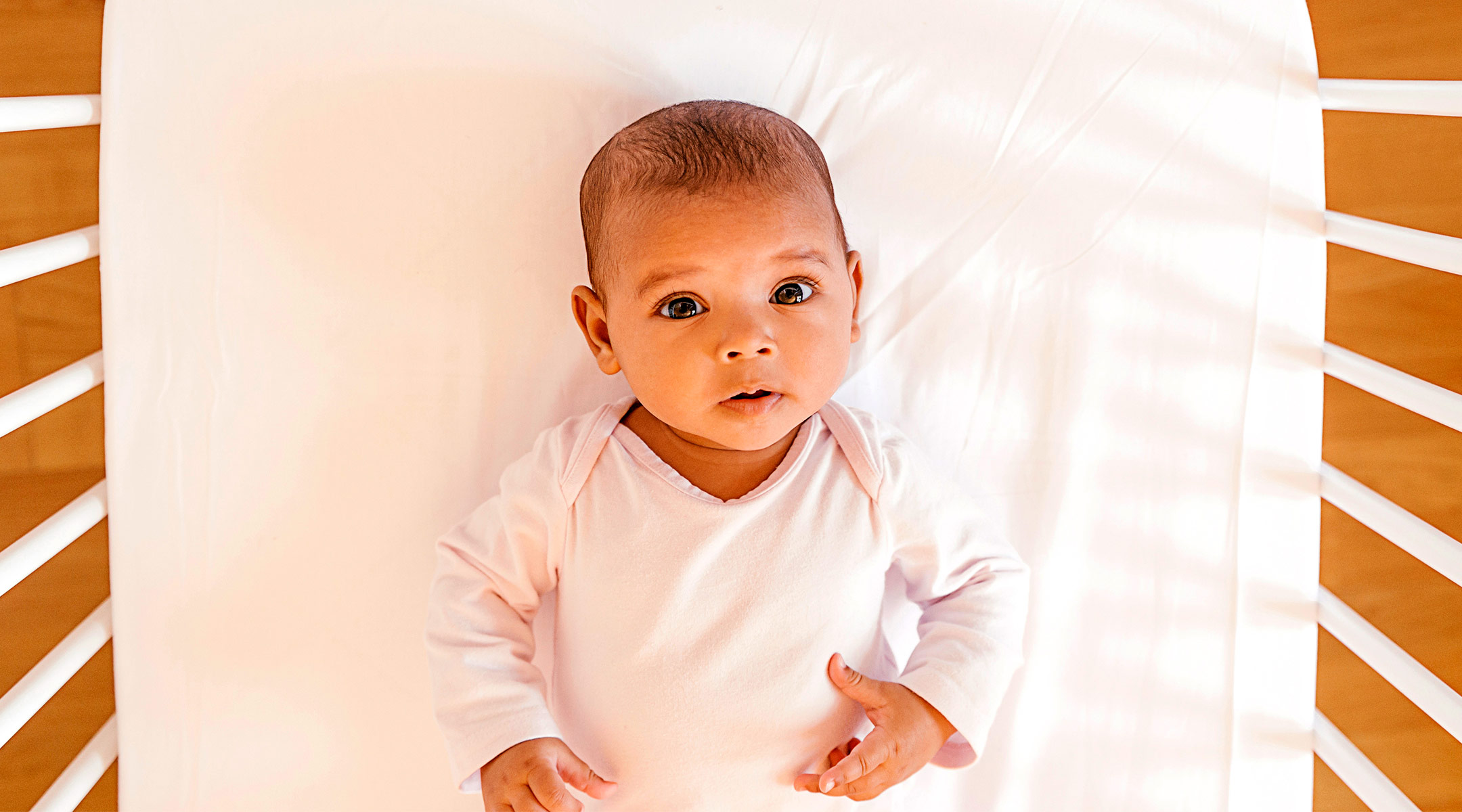 baby in crib looking at camera