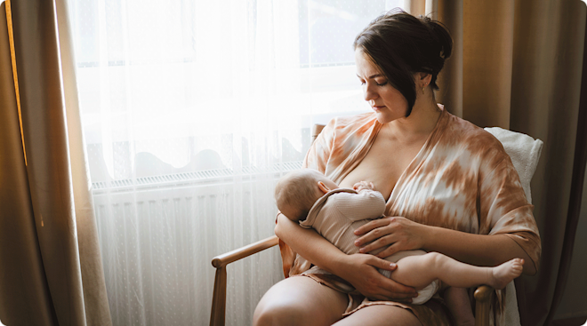 mother breastfeeding newborn baby at home