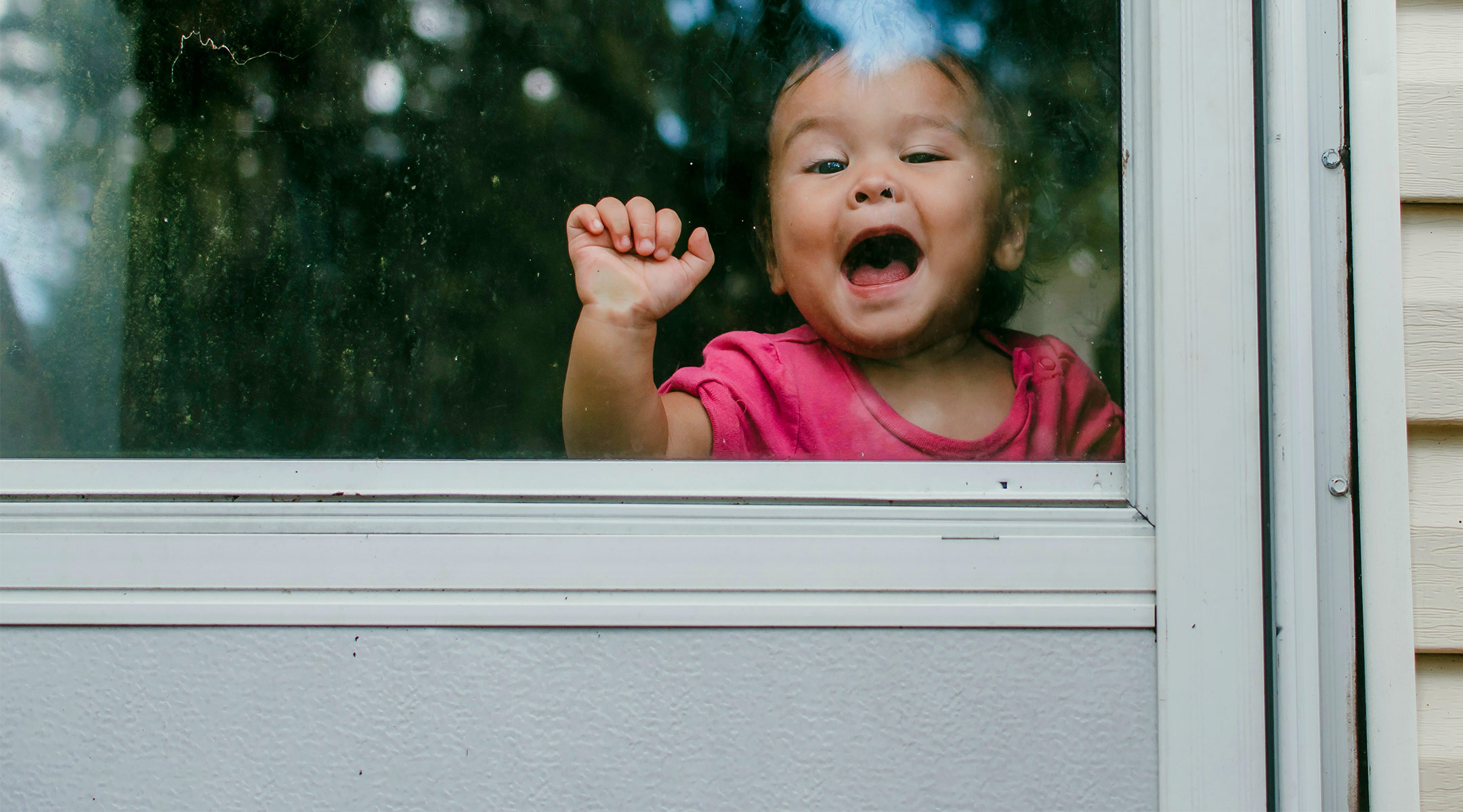 toddler girl knocking behind glass back door