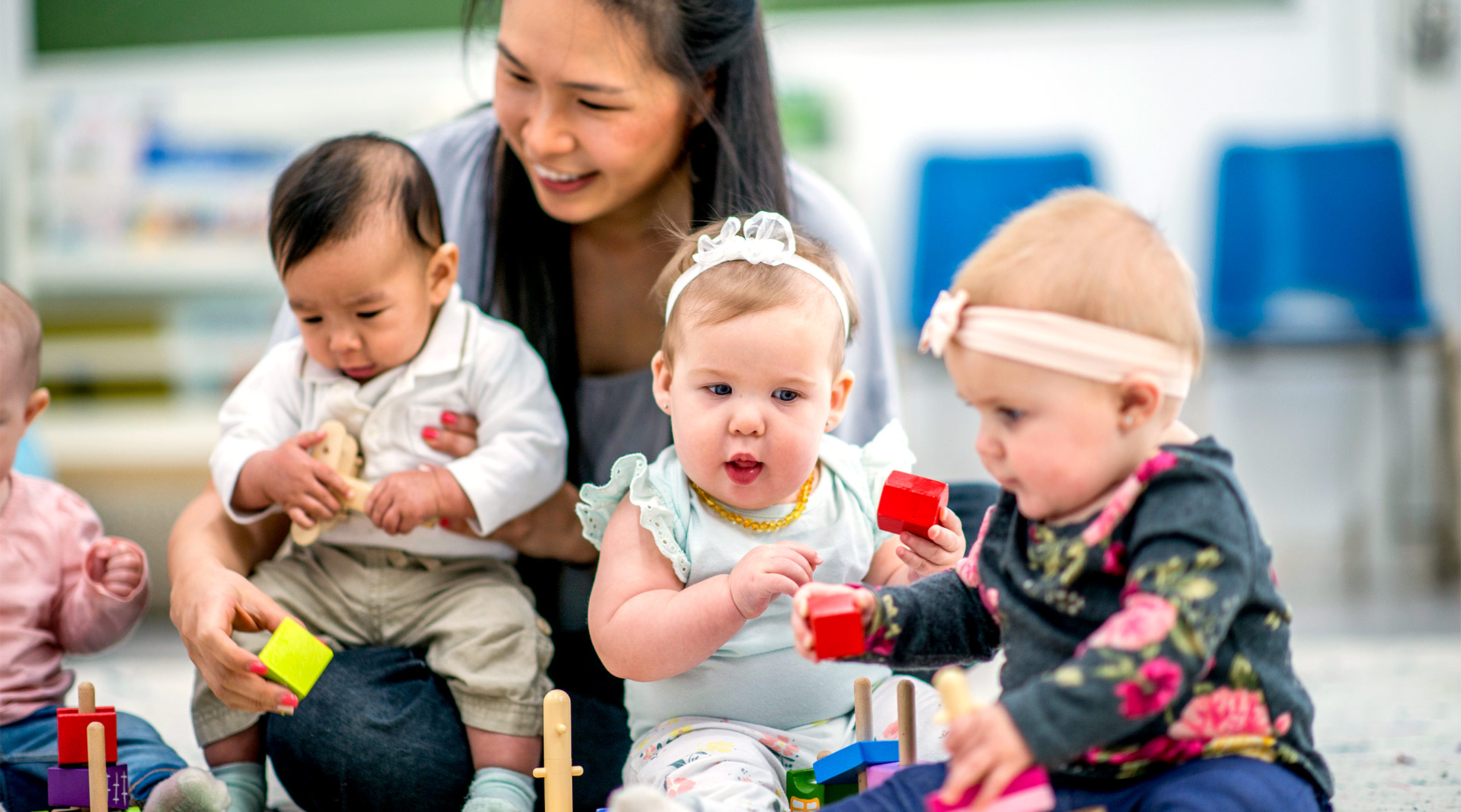 daycare teacher interacting with her baby students