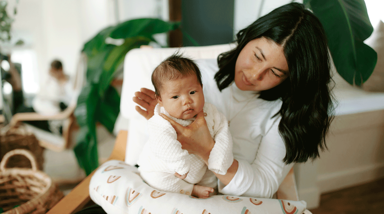 mother burping baby on lap 