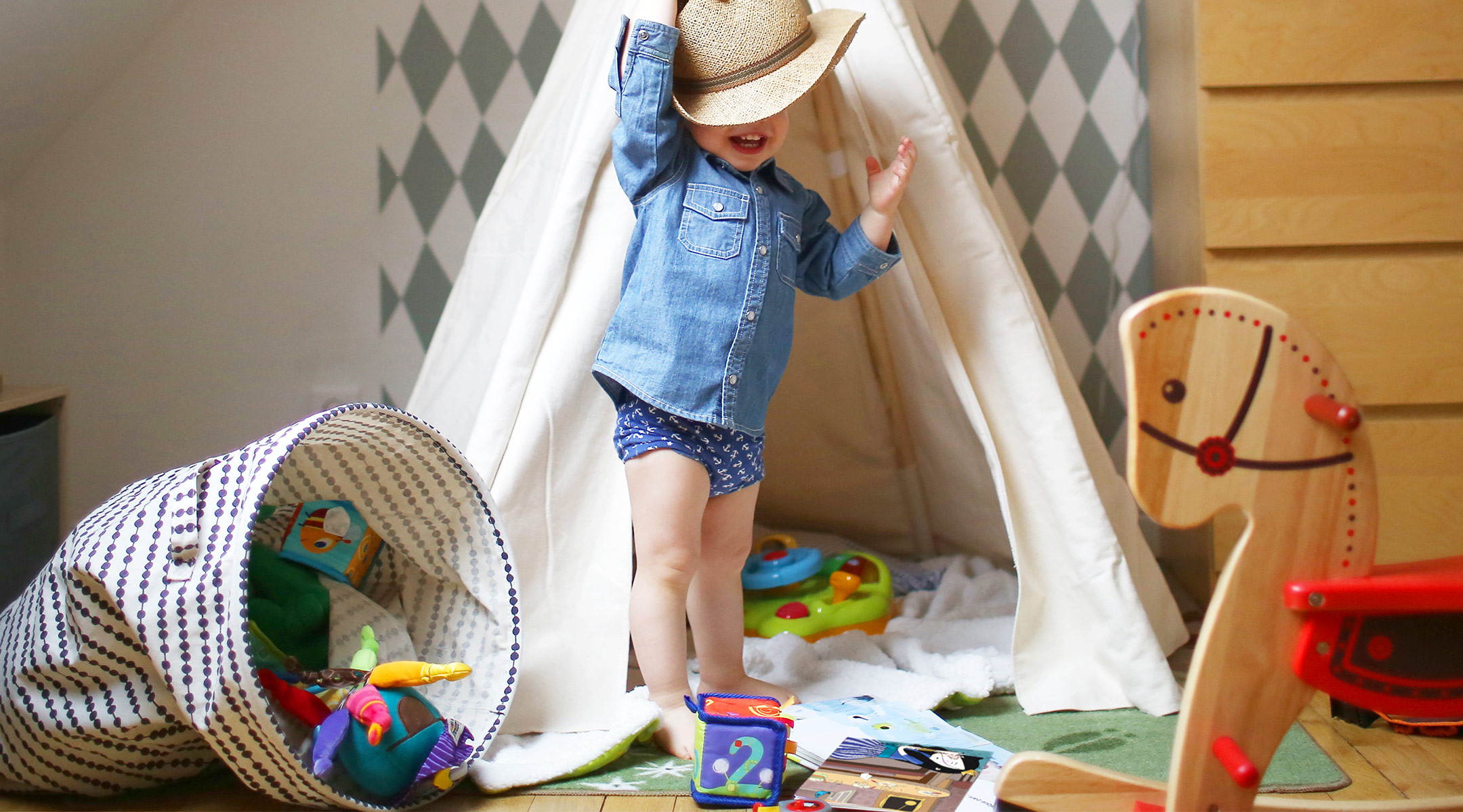 toddler playing in his room with toys and teepee