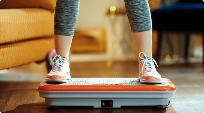 woman standing on vibration plate at home