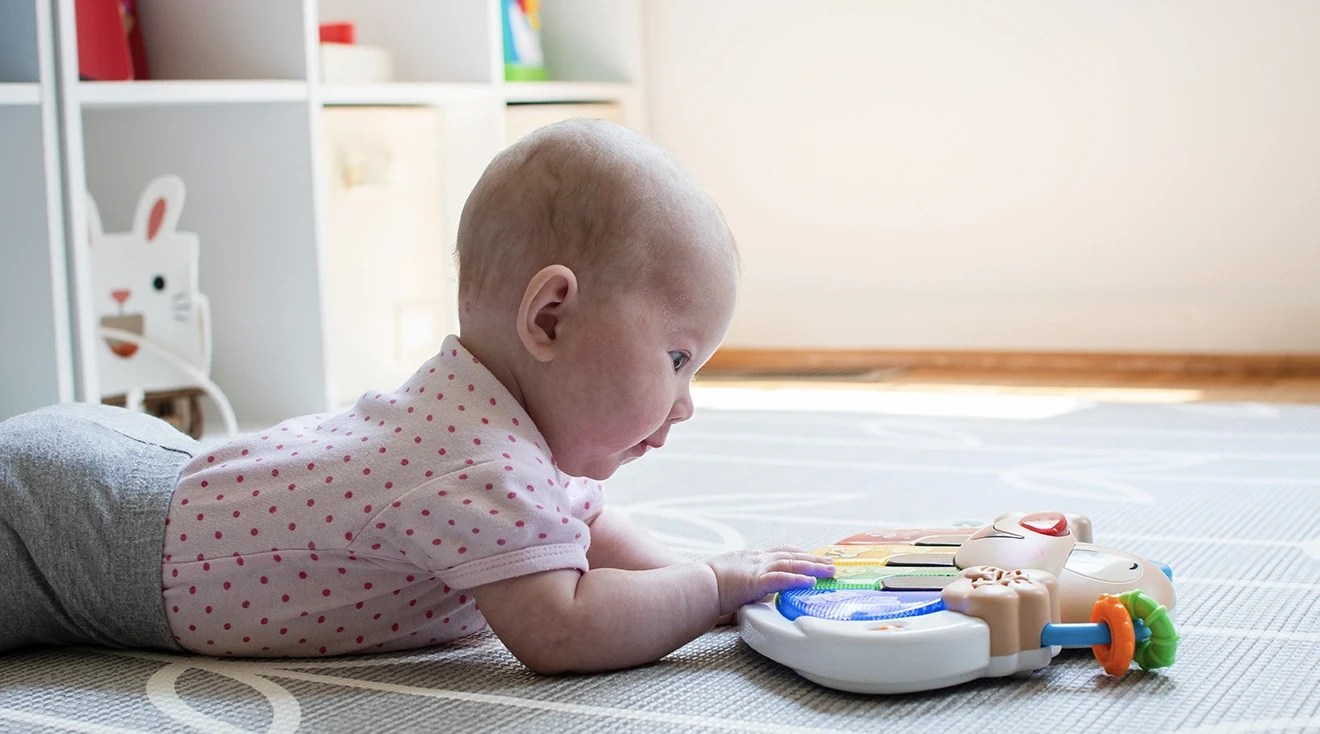 baby doing tummy time while playing with toy