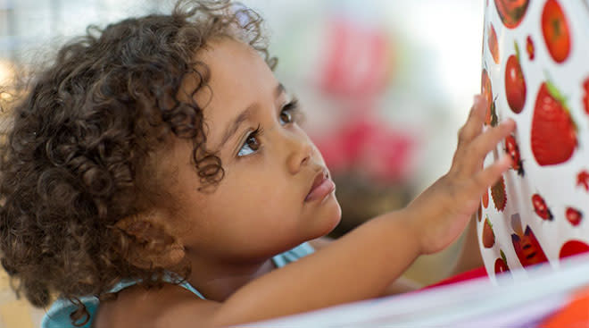 toddler looking through a book
