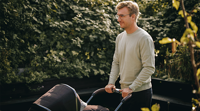 smiling dad pushing baby stroller