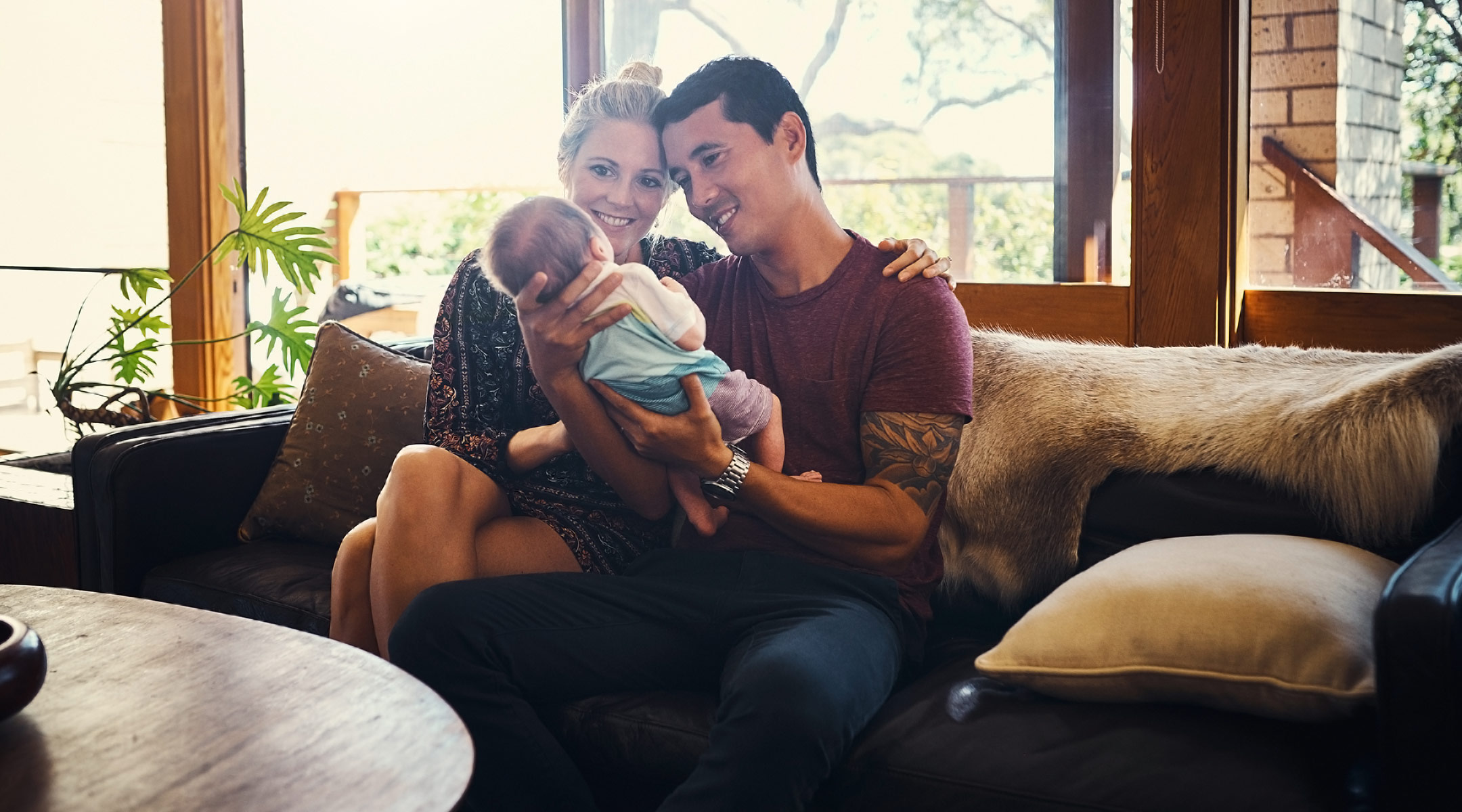 new parents happily holding their newborn baby