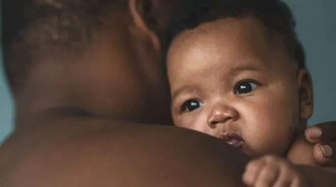 father holding baby at home