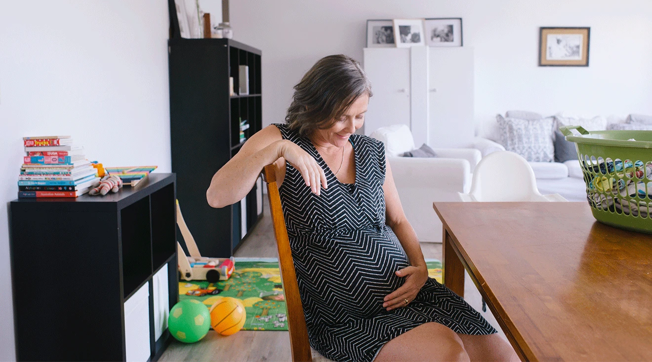 mature pregnant woman sitting at home