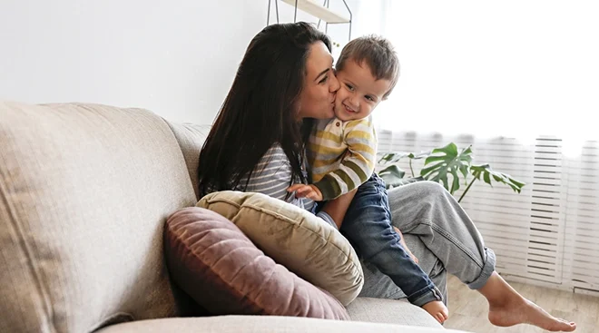 stay at home mother sitting on couch with toddler at home