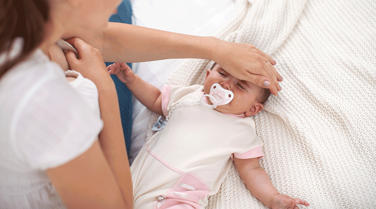 mother feeling baby's head for fever