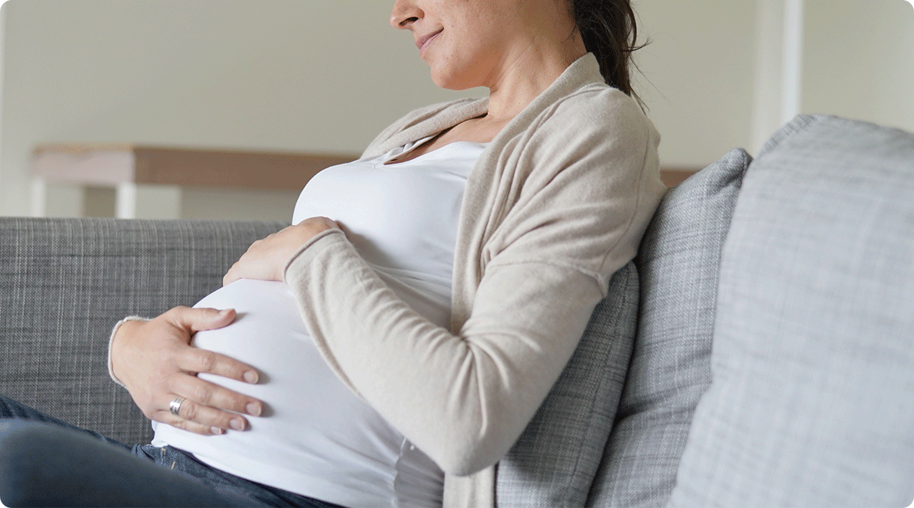 pregnant woman sitting on couch at home