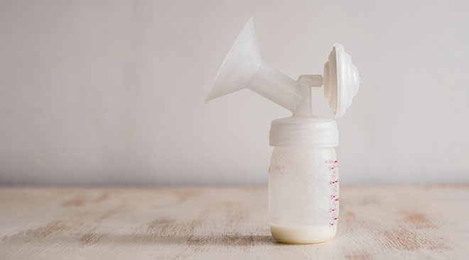 breast pump attached to bottle with a small amount of breast milk