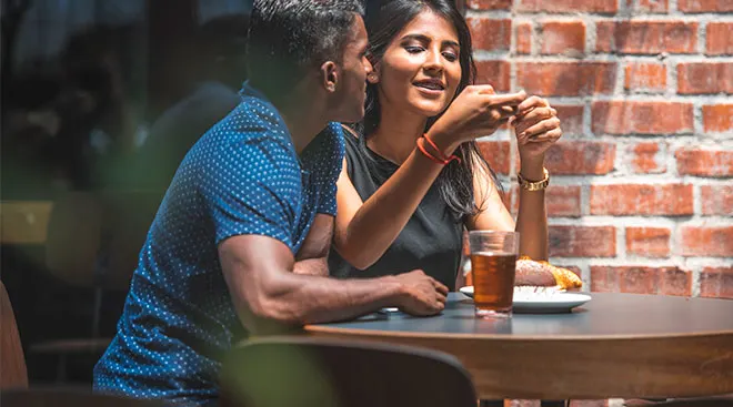 couple talking and sitting at table in a cafe